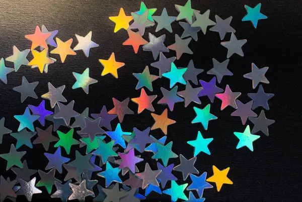 Koyu renkli konfeti yıldız karanlık bir arka plan üzerinde