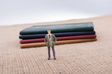 Adam heykelcik ayakta tuval üzerine küçük kitap yanında