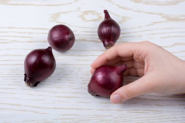 Tüm kırmızı soğan soğanları kahverengi ve ahşap arka planda