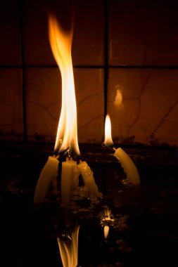 Karanlıkta mum ışığında yanan mumlar.