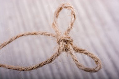 Açık renk arka plan üzerinde düğüm olarak bağlı iş parçacığı