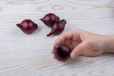 Tüm kırmızı soğan soğanları kahverengi ve ahşap arka planda