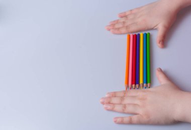 Beyaz arkaplana yerleştirilmiş el ele tutuşan kalemler