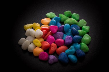 Siyah arkaplanda küçük renkli çakıl yığınları