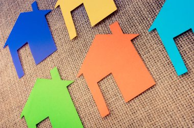 Tuvalin arka planında renkli kağıttan kesilmiş küçük bir ev şekli