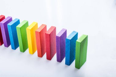 Beyaz arka planda renkli Domino Blokları elinde