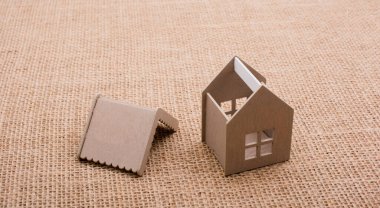 Keten bir tuvale yerleştirilmiş küçük model ev.