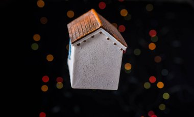 Bokeh ışıklı arka planda küçük bir model ev