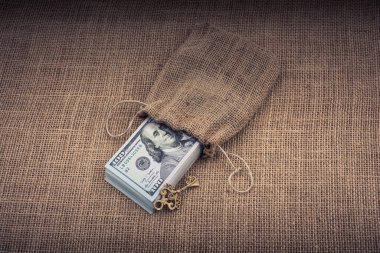 Retro anahtar ve bir çuval dolusu Amerikan doları tuvalde.