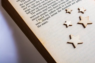 Kitap sayfasına yerleştirilmiş küçük tahta yıldızlar