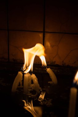 Karanlıkta mum ışığında yanan mumlar.