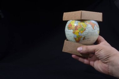 Hand holding a globe  with map on it clipart