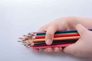 Beyaz arkaplana yerleştirilmiş el ele tutuşan kalemler