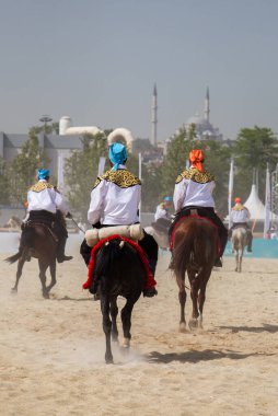 Atlılar at sırtında etnik kıyafetleriyle geziyorlar.