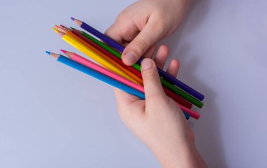 Beyaz arkaplana yerleştirilmiş el ele tutuşan kalemler