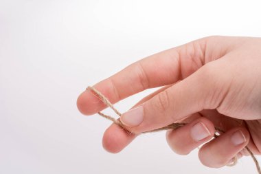 Keten iplik beyaz bir arka plan üzerinde tutan el