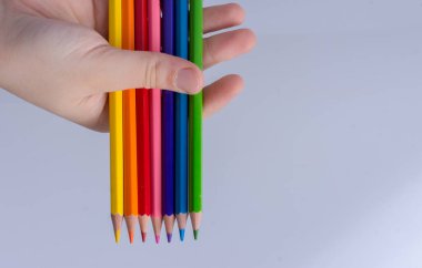 Beyaz arkaplana yerleştirilmiş el ele tutuşan kalemler