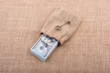 Retro anahtar ve bir çuval dolusu Amerikan doları tuvalde.