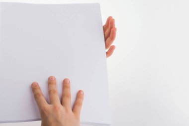 Beyaz bir arka plan üzerinde beyaz bir boş sayfa tutan el