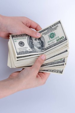 İnsan eli, Amerikan doları banknotunu beyaza izole edilmiş olarak tutuyor.