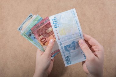 El ele tutuşan Amerikan doları banknotları ahşap arka planda izole edilmiş.