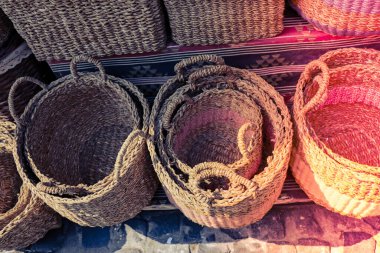 Empty wicker baskets are for sale in a market place clipart