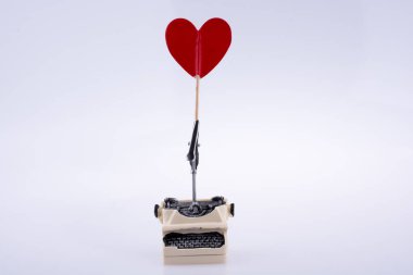 Heart shape icon on a typewriter on white background clipart