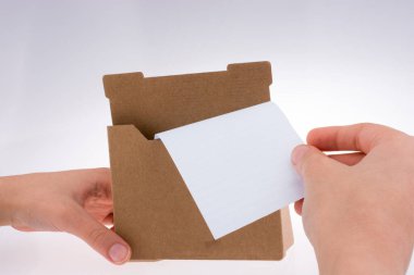 Beyaz arka plan üzerinde kağıt tutucu durmak el ulaşır