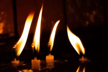 Mumlar karanlıkta sarı alevlerle yanıyor.