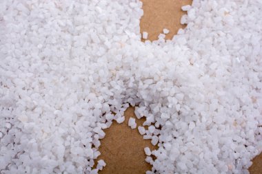 Tahta zemine saçılmış küçük beyaz taşlar.