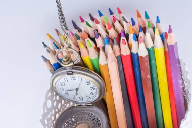 Retro tarzı klasik cep saati ve renk kalem beyaz arka plan üzerinde