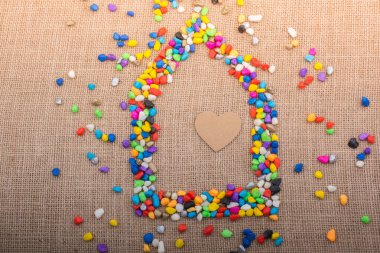 Renkli çakıl taşlarıyla şekillendirilmiş evdeki kalp.