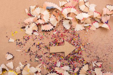 Kağıttan kesilen ok tuval üzerindeki kalem talaşları arasında