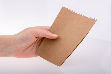 Beyaz arka planda bir sayfa kağıt tutarken