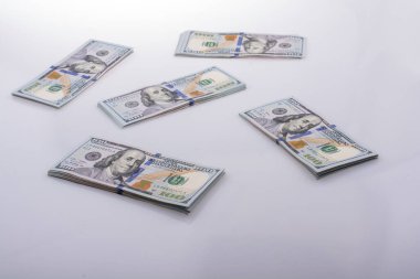Beyaz zemin üzerine yerleştirilmiş Amerikan 100 dolarlık banknot demetleri