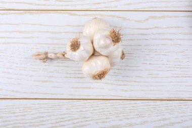 Ahşap dokusu üzerinde yerleştirilen sarımsak karanfil