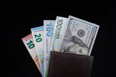 El ele tutuşan Amerikan doları banknotları siyah arka planda izole edilmiş.