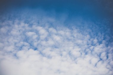 Beyaz renkli bulutlar gündüz vakti mavi gökyüzünü kaplar.