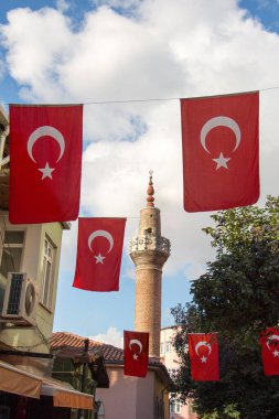 Bir minare bir iple bir direğe Türk ulusal bayrak dayan
