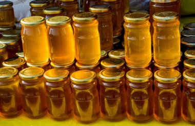 Kapaklı taze bal dolu cam kavanoz.