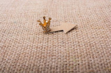 Mini taç ve tuval üzerinde kağıt ok.