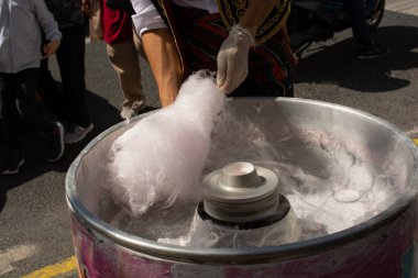 Sokak pazarında pamuk şeker yapma süreci. Sokak yemekleri ve yiyecekler.