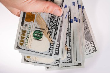 İnsan eli, Amerikan doları banknotunu beyaza izole edilmiş olarak tutuyor.