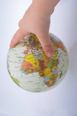 Beyaz arka planda bir küreyi tutan çocuk