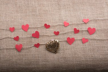 Love concept with heart shaped papers on linen threads clipart