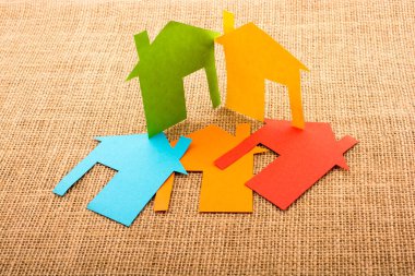 Tuvalin arka planında renkli kağıttan kesilmiş küçük bir ev şekli