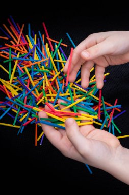 Beyaz arka planda yaratıcılık için renkli tahta çubuklarla oynayan çocuk