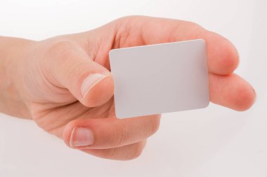 Beyaz arka planda bir kağıt parçasını tutan el.