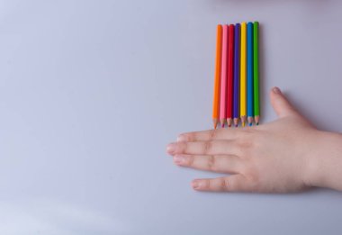 Beyaz arkaplana yerleştirilmiş el ele tutuşan kalemler