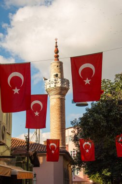 Bir minare bir iple bir direğe Türk ulusal bayrak dayan